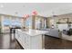 Open concept kitchen featuring a white island, modern lighting, and seamlessly connected living spaces at 7408 Xenophon St, Arvada, CO 80005