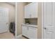 Convenient laundry room features built-in cabinets, countertop, and modern washer and dryer at 7408 Xenophon St, Arvada, CO 80005