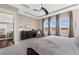 Bright main bedroom with a large window, tray ceiling, and neutral carpeting at 7408 Xenophon St, Arvada, CO 80005