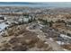 Expansive aerial view of luxury home shows the surrounding landscape and neighborhood with rolling hills and mature trees at 3520 Castle Butte Dr, Castle Rock, CO 80109