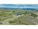 Aerial view of an estate home showcasing its elegant design and beautiful landscaping amidst rolling hills and trees at 3520 Castle Butte Dr, Castle Rock, CO 80109