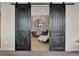 Sliding barn doors reveal a bathroom with a freestanding tub and stone accent wall at 3520 Castle Butte Dr, Castle Rock, CO 80109