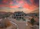 Stunning home with a driveway, backyard patio, and water feature at sunset at 3520 Castle Butte Dr, Castle Rock, CO 80109