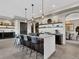 Open kitchen with island, barstool seating, sleek countertops, and modern lighting at 3520 Castle Butte Dr, Castle Rock, CO 80109