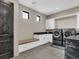 A modern laundry room features front-load washer and dryer, storage cabinets, and stylish tiled floors at 3520 Castle Butte Dr, Castle Rock, CO 80109
