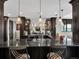 A full wet bar with hanging pendant lights, marble countertop, and glass shelving at 3520 Castle Butte Dr, Castle Rock, CO 80109