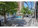 Inviting outdoor seating area with blue tables, lush trees, and a vibrant atmosphere, perfect for dining and relaxing at 1625 Larimer St # 2601, Denver, CO 80202