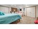 Basement bedroom with twin beds, a small TV, and closet space separated by double doors at 2777 S Elmira St # 17, Denver, CO 80231