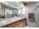 Bright bathroom featuring a wide mirror, granite countertop, and walk-in shower with glass doors at 2777 S Elmira St # 17, Denver, CO 80231