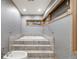 Modern bathroom with built-in soaker tub, unique wallpaper, and neutral color scheme at 2777 S Elmira St # 17, Denver, CO 80231