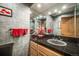 Modern bathroom with patterned wallpaper, granite countertops, and decorative towels at 2777 S Elmira St # 17, Denver, CO 80231