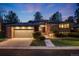 Charming brick home with well-lit two-car garage and meticulously landscaped front yard at dusk at 2777 S Elmira St # 17, Denver, CO 80231