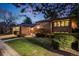 Charming brick home with meticulously landscaped front yard and walkway at dusk at 2777 S Elmira St # 17, Denver, CO 80231