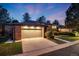 Charming brick home with well-lit two-car garage and meticulously landscaped front yard at dusk at 2777 S Elmira St # 17, Denver, CO 80231