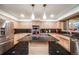 Modern kitchen with stainless steel appliances, black countertops, and stylish pendant lighting at 2777 S Elmira St # 17, Denver, CO 80231