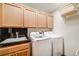 A laundry room with plenty of cabinet storage, a sink, and newer washer and dryer at 2777 S Elmira St # 17, Denver, CO 80231