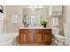 Well-lit bathroom featuring a wooden vanity, white fixtures, and a shower/tub combination at 10176 Park Meadows Dr # 2408, Lone Tree, CO 80124