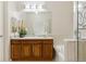 Elegant bathroom featuring a vanity with wood cabinets, a spacious mirror, and a bathtub with a glass shower at 10176 Park Meadows Dr # 2408, Lone Tree, CO 80124