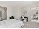 Bright bedroom with a view into the living room, plush bedding, and a modern writing desk setup at 10176 Park Meadows Dr # 2408, Lone Tree, CO 80124