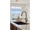 Close-up of a modern kitchen sink and faucet, island with seating and city views at 10176 Park Meadows Dr # 2408, Lone Tree, CO 80124