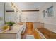 Bright bathroom featuring a dual vanity and bathtub with wood accents at 638 Kinnikinnik Hl, Golden, CO 80401