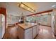 Open concept kitchen and dining area featuring hardwood floors, wooden beams, island and stainless appliances at 638 Kinnikinnik Hl, Golden, CO 80401