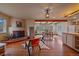 Open-concept living room with a fireplace, hardwood floors, and beamed ceilings leading to a dining area at 638 Kinnikinnik Hl, Golden, CO 80401