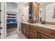 Bathroom featuring double sinks, wood cabinetry, and access to the primary bedroom at 4937 Hogback Ridge Rd, Morrison, CO 80465