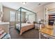 Cozy bedroom featuring a four-poster bed, neutral colors, and bright natural light from the windows at 4937 Hogback Ridge Rd, Morrison, CO 80465