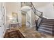 Grand foyer featuring stone flooring, a staircase with iron railings, and elegant decor at 4937 Hogback Ridge Rd, Morrison, CO 80465