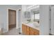 Bathroom featuring dual vessel sinks, wood cabinets, and a view to tub and walk-in closet at 23612 E Mississippi Cir, Aurora, CO 80018