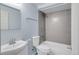 Bathroom featuring gray tiled shower and tub, blue walls, and a modern sink at 23612 E Mississippi Cir, Aurora, CO 80018