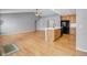 Kitchen island featuring wood cabinets with black dishwasher and sink with a view into the living room at 23612 E Mississippi Cir, Aurora, CO 80018