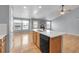 Kitchen island featuring wood cabinets with black dishwasher, and view into the living room and fireplace at 23612 E Mississippi Cir, Aurora, CO 80018