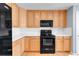 Kitchen featuring wood cabinetry, black appliances, white subway tile backsplash, and countertops at 23612 E Mississippi Cir, Aurora, CO 80018