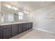 Double vanity bathroom with dark brown cabinets and a large mirror at 12224 Olive Way, Thornton, CO 80602