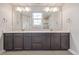 Double vanity bathroom with dark brown cabinets and a large mirror at 12224 Olive Way, Thornton, CO 80602