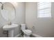 Simple bathroom with pedestal sink, toilet, and a large vanity mirror at 12224 Olive Way, Thornton, CO 80602