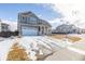 Two-story house with gray siding, white garage door, and a driveway, snow on the ground at 12224 Olive Way, Thornton, CO 80602