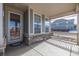 Covered porch with stone accents and a glass front door at 12224 Olive Way, Thornton, CO 80602