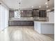 Spacious kitchen with dark cabinets, white island, and herringbone backsplash at 12224 Olive Way, Thornton, CO 80602