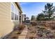 Landscaped backyard featuring a stone walkway, rock garden, and a covered patio with an outdoor seating area at 9587 Kentwick Cir, Englewood, CO 80112