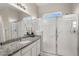 Well-lit bathroom featuring granite countertops, double shower, and ample counter space at 9587 Kentwick Cir, Englewood, CO 80112