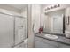 Bright bathroom featuring granite vanity and a glass enclosed shower, providing a fresh, clean aesthetic at 9587 Kentwick Cir, Englewood, CO 80112