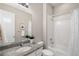 Well-lit bathroom featuring a granite vanity top, white cabinets, and a shower-tub combination with white tile surround at 9587 Kentwick Cir, Englewood, CO 80112