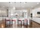 Kitchen island with seating, stainless steel appliances, white cabinets, hardwood floors, and staircase to upper floor at 9587 Kentwick Cir, Englewood, CO 80112