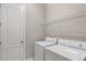 Practical laundry room with modern washer, dryer, and ample shelving for efficient organization at 9587 Kentwick Cir, Englewood, CO 80112