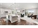 Bright, open-concept kitchen and living room featuring hardwood floors, white cabinetry, a large island, and a cozy fireplace at 9587 Kentwick Cir, Englewood, CO 80112