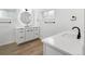 Modern bathroom with a circular LED mirror, double vanity, and wood-look tile flooring at 2175 S Joliet St, Aurora, CO 80014