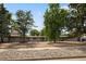 Single story home featuring a well-manicured yard with mature trees and rock ground covering at 2175 S Joliet St, Aurora, CO 80014